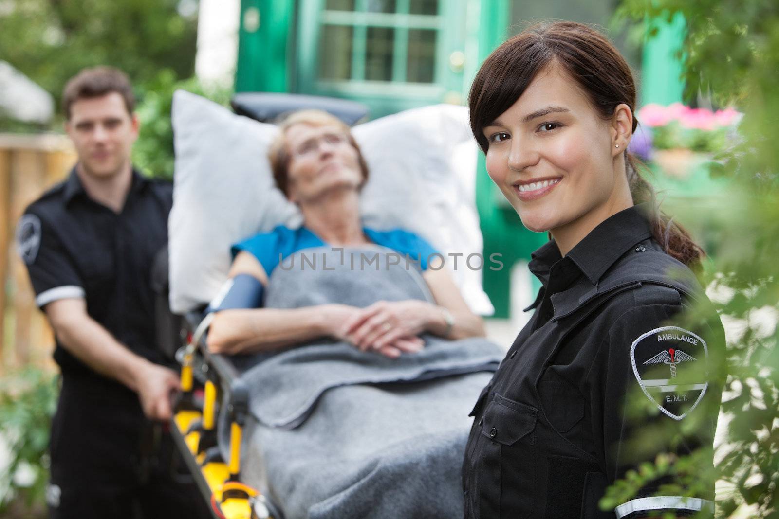 Portrait of woman ambulance worker with stretcher