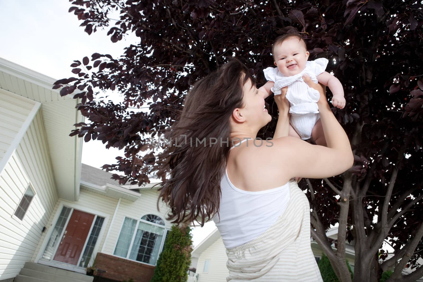 Portrait of happy young mother with baby girl outdoors