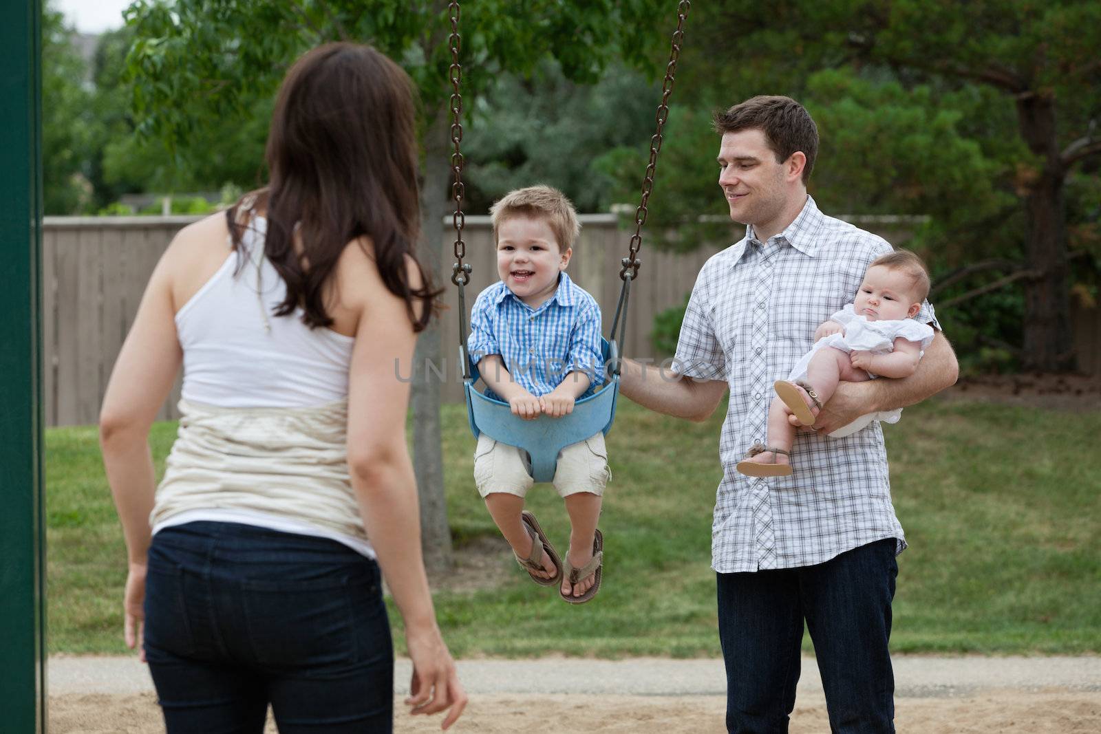 Family having fun with their children in playground