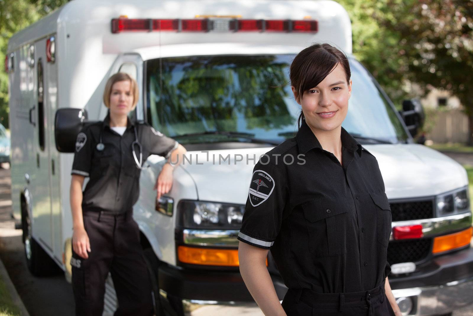 Emergency medical workers standing with ambulance