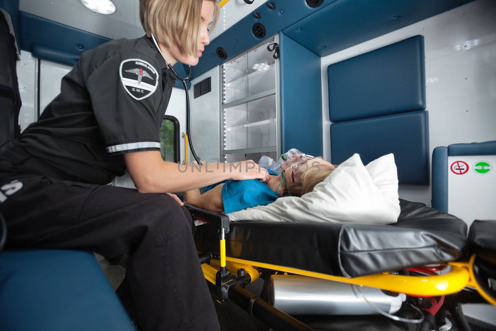 Senior woman receiving emergency medical care in ambulance