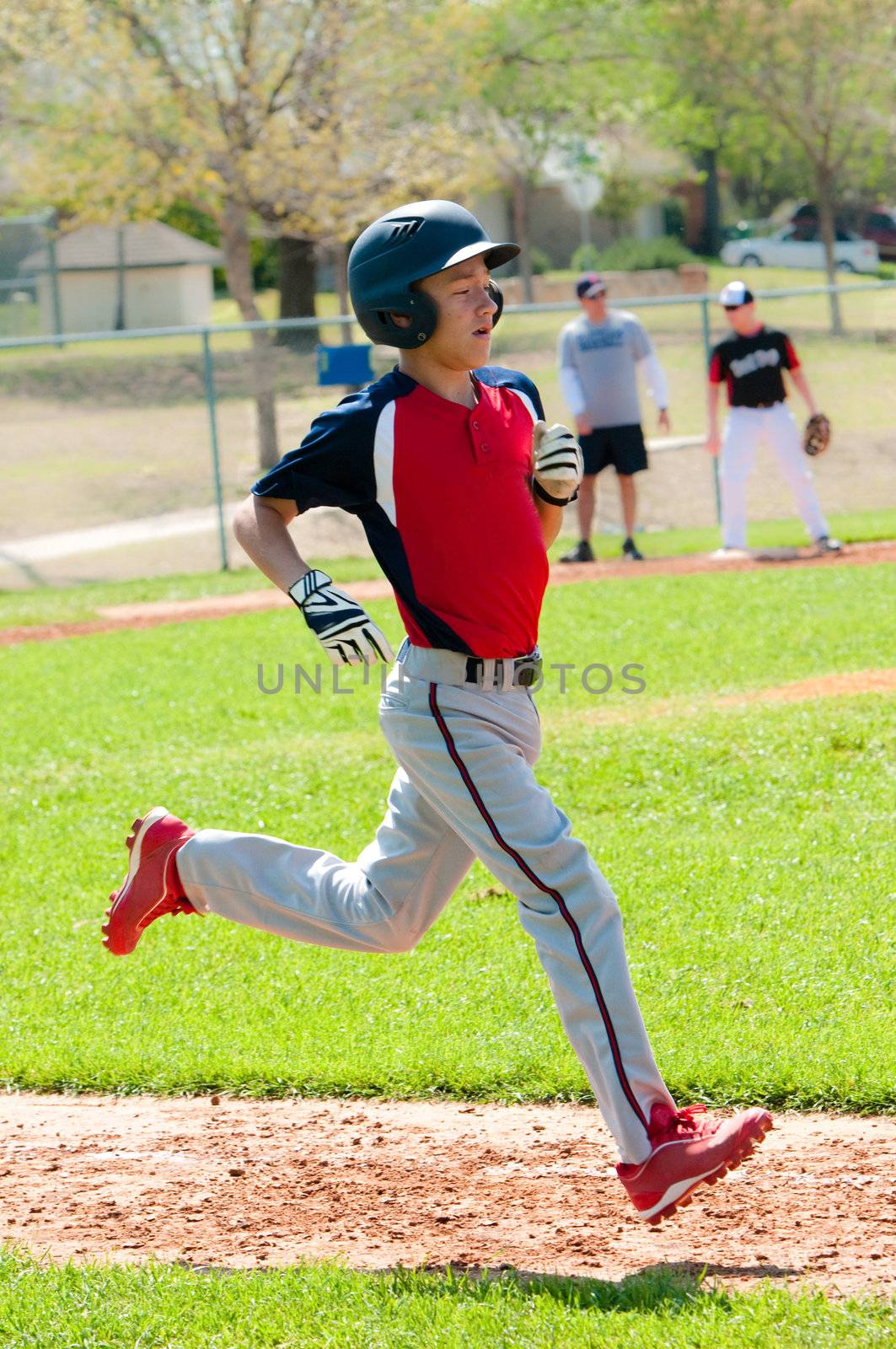 Teen baseball boy running to base.