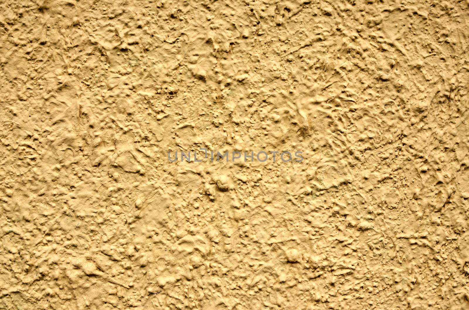 A yellow stucco wall useful for backgrounds or textures