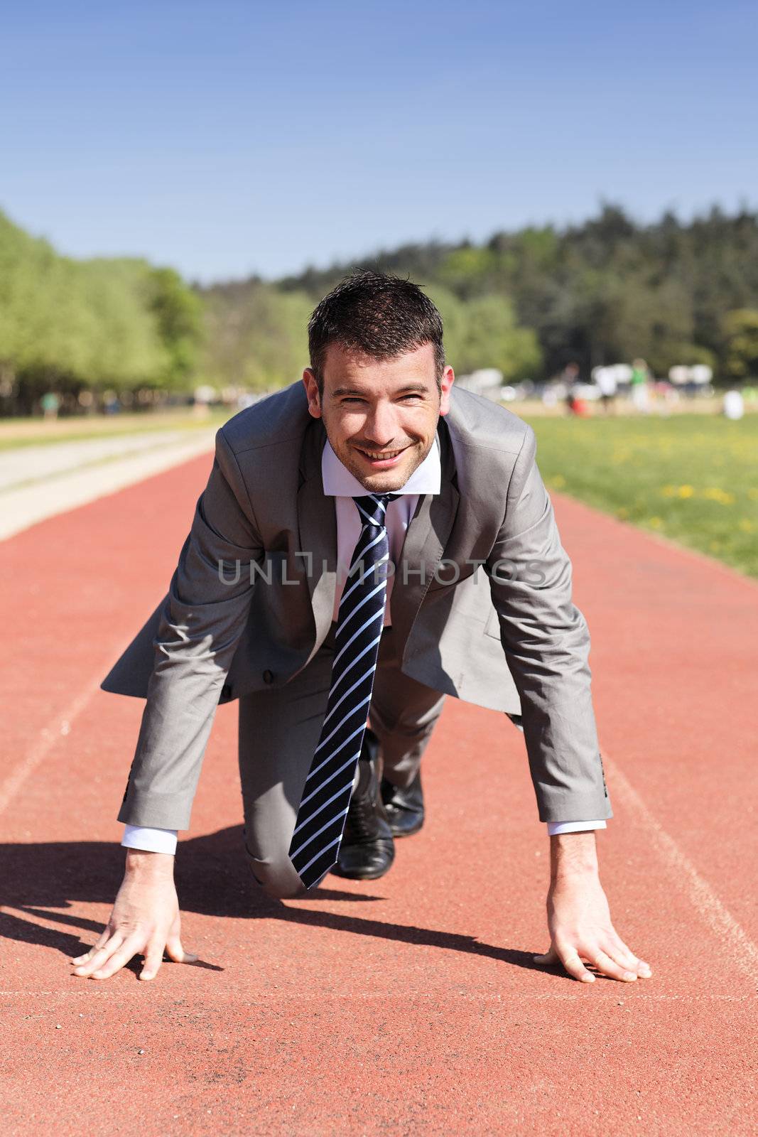 young businessman on a running track in summer