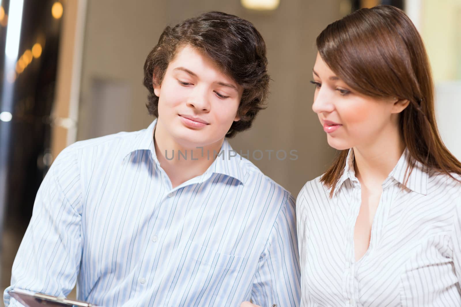 Attractive young man and woman sitting on the floor talking