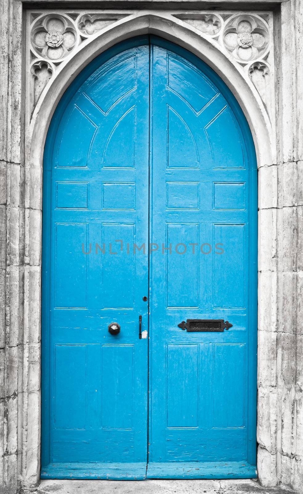 A tall blue church doorway in a gothic stone wall