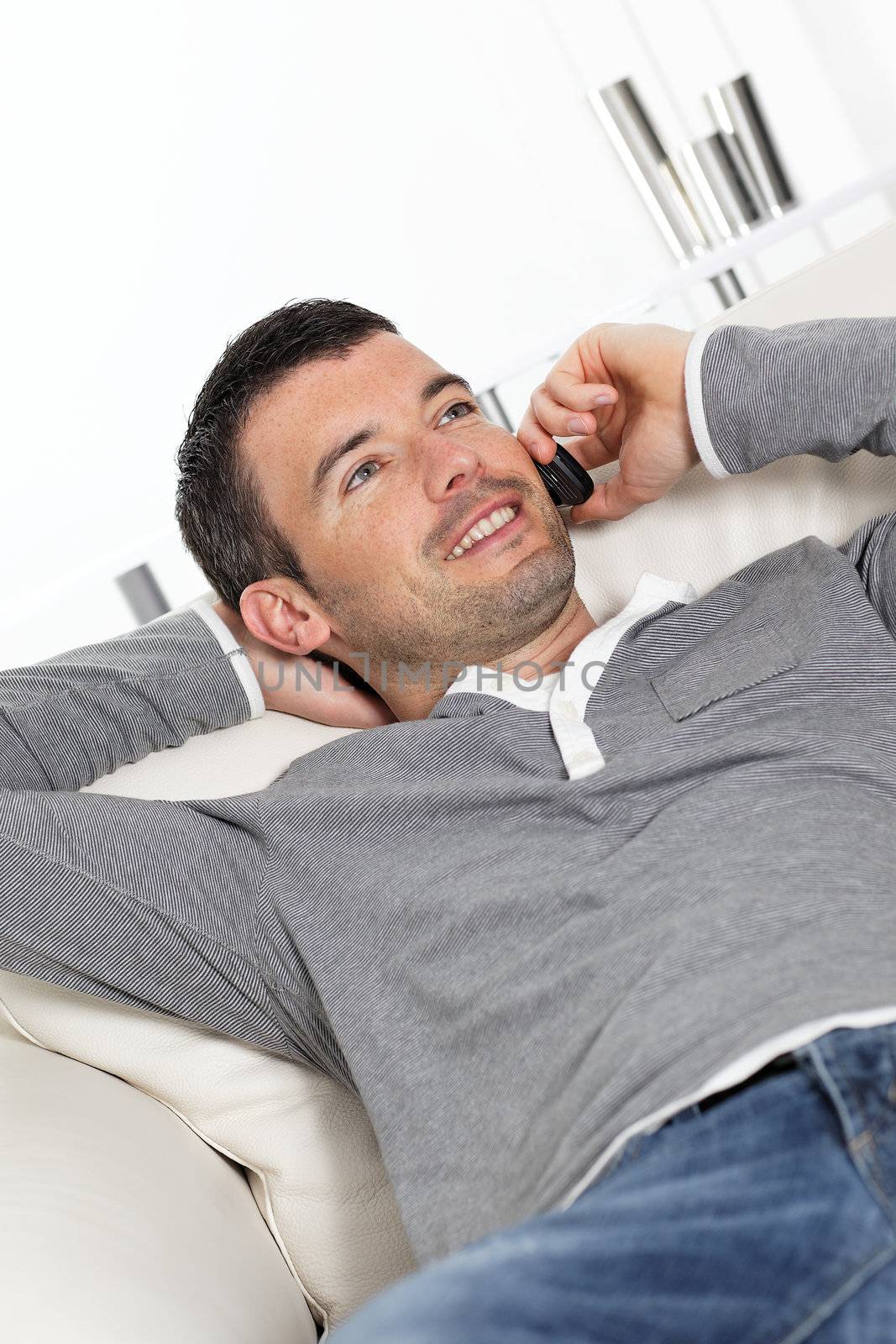 man phoning on sofa