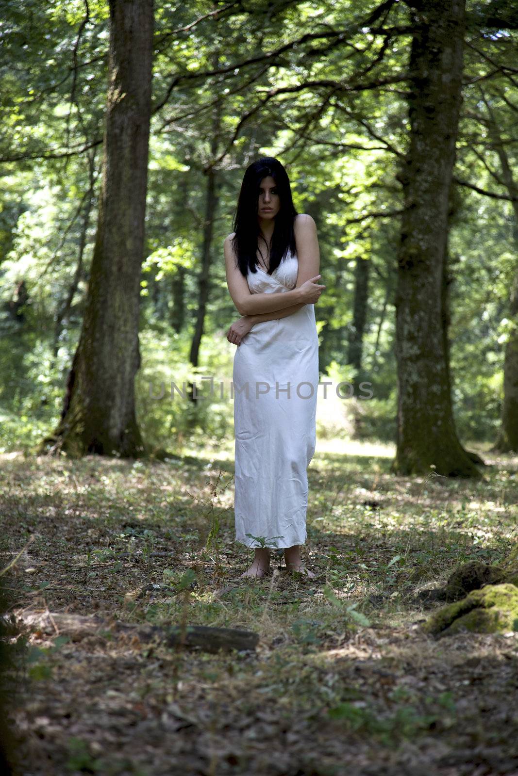 Fashion model with lingerie lonely in a forest with trees