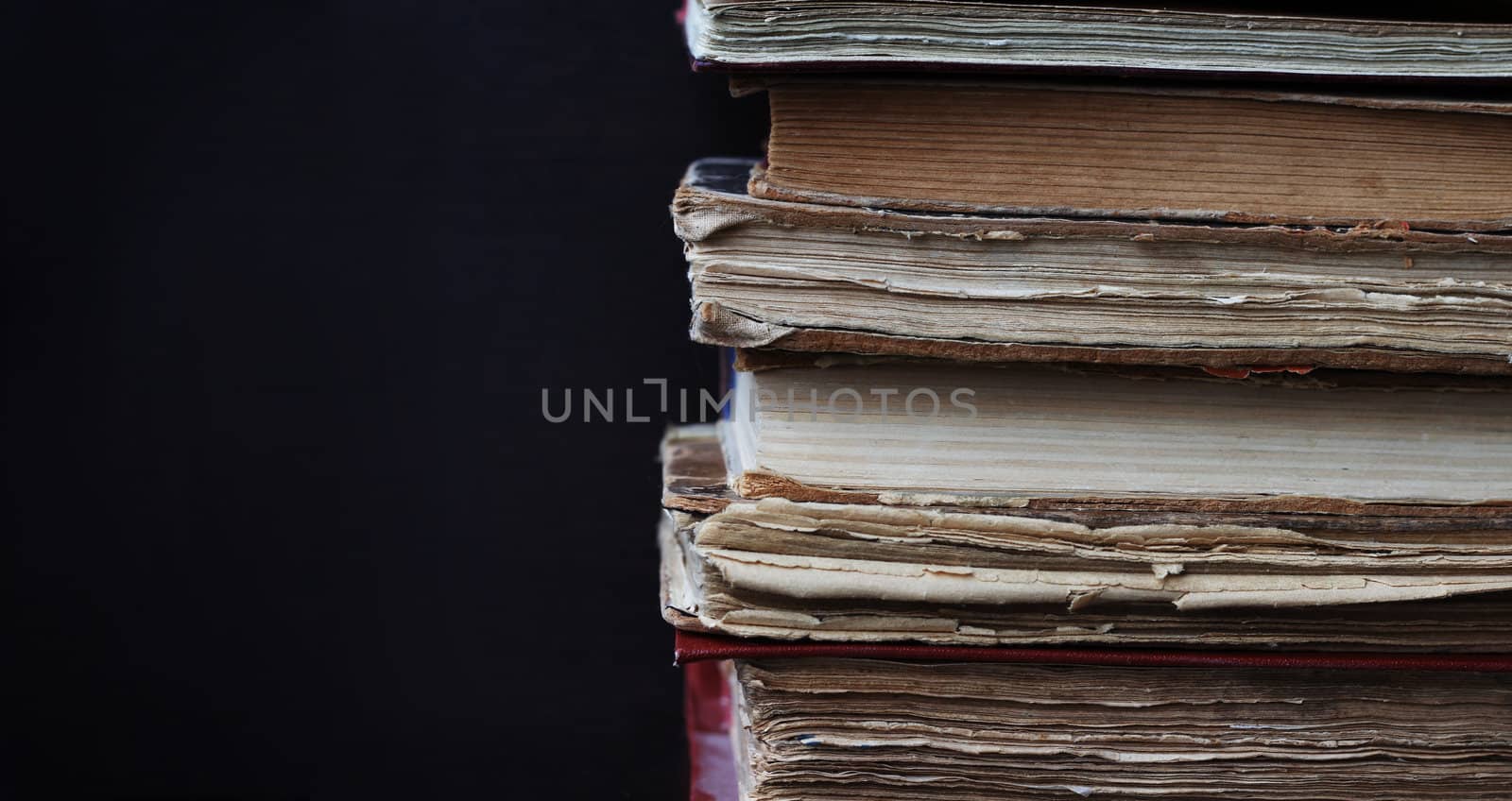 Stack of old books on dark background