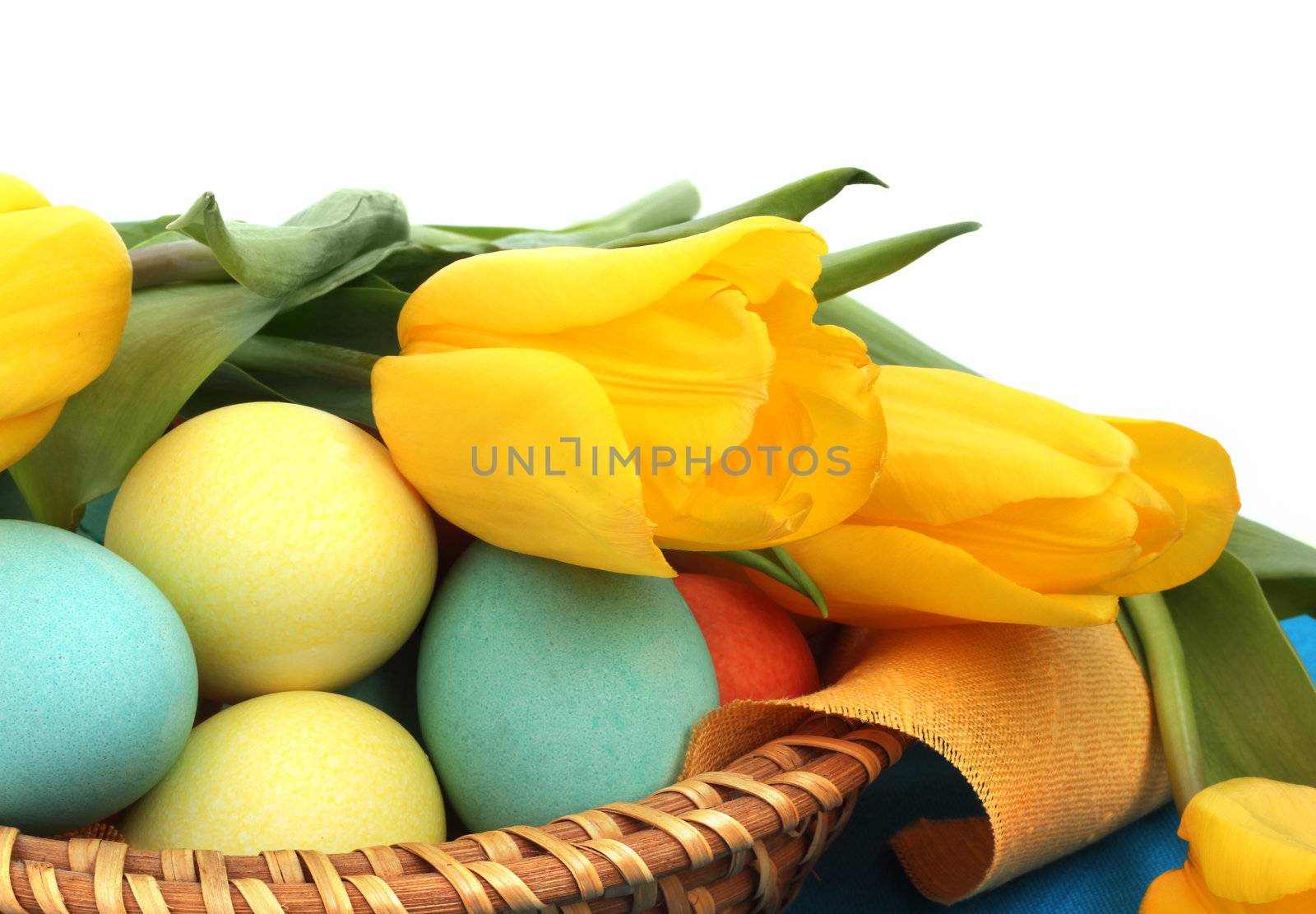 Easter eggs in basket with tulips by destillat