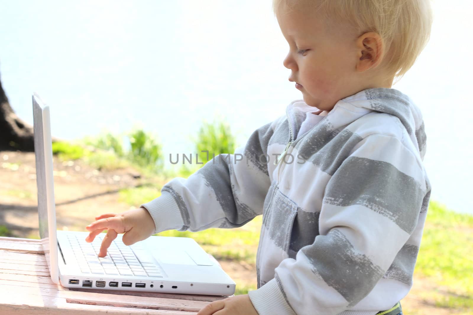 Small child pressing the button on laptop