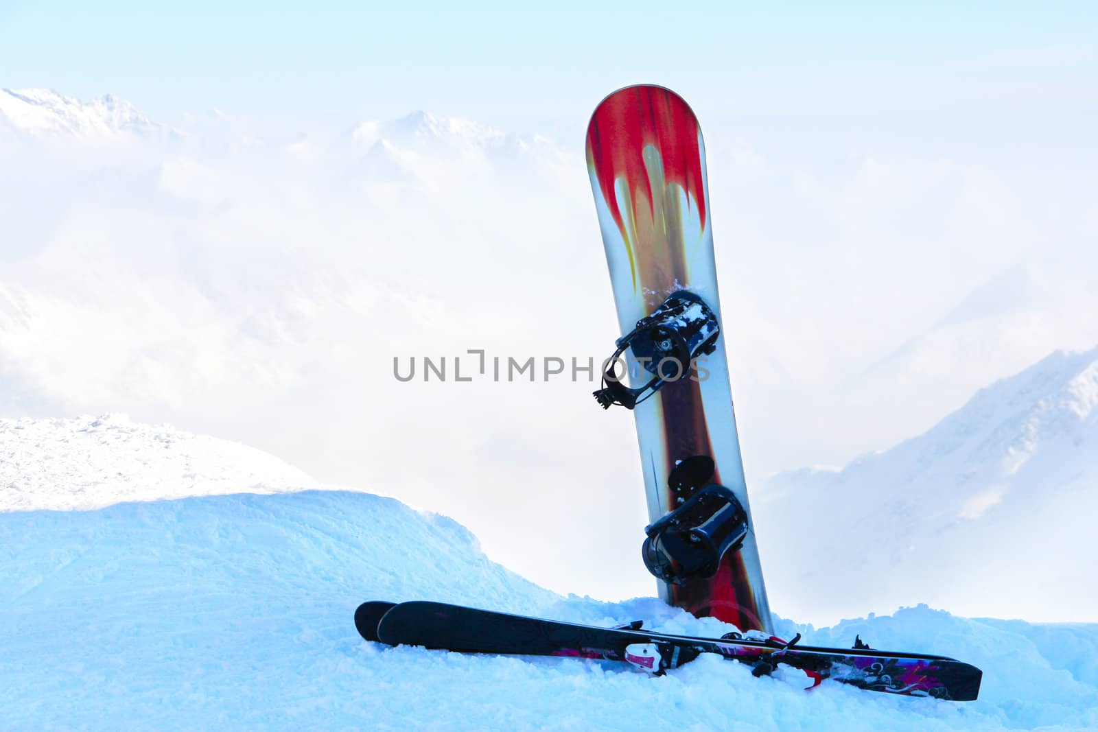 Snowboard and ski in mountains by destillat