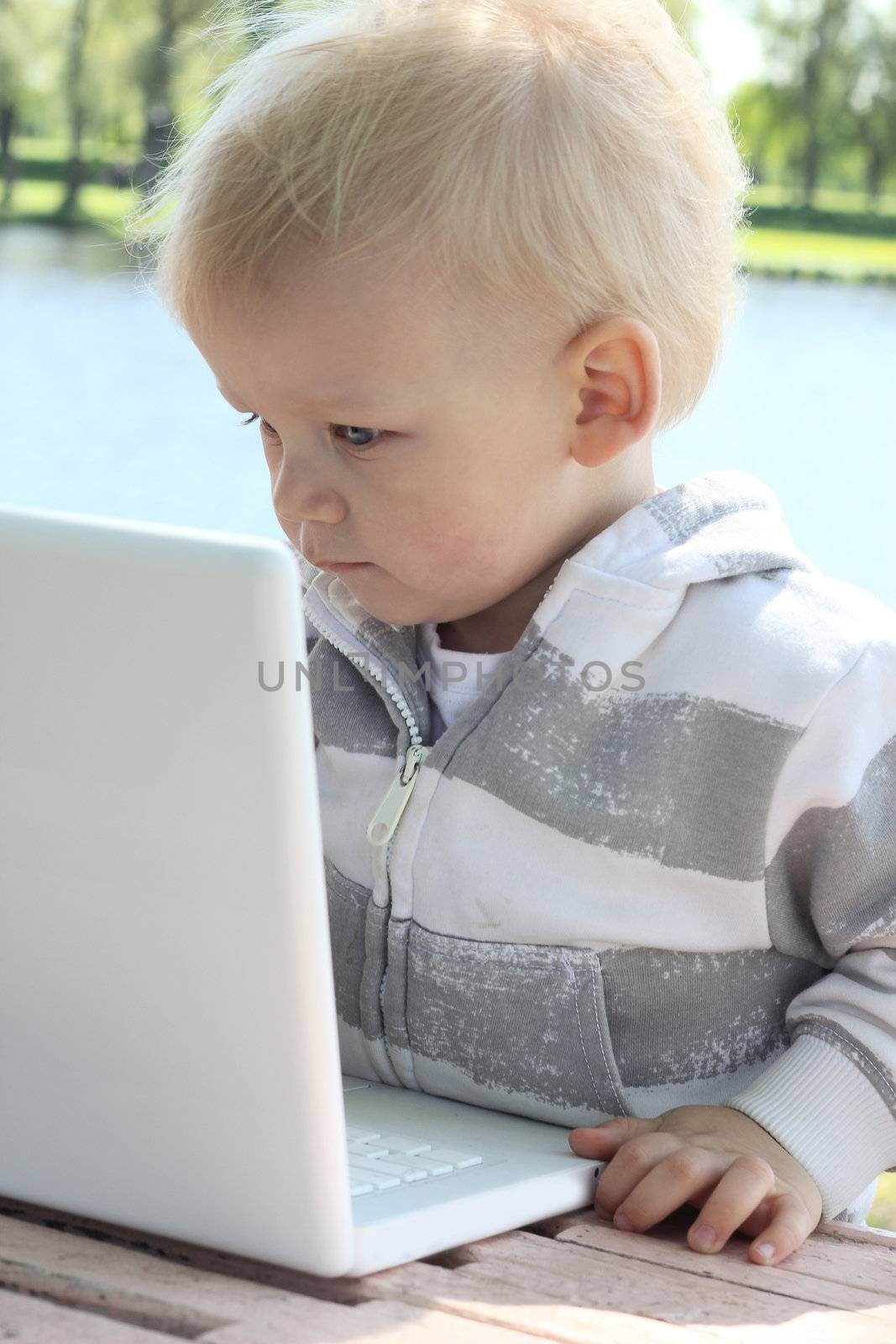 small child working with laptop outdoor