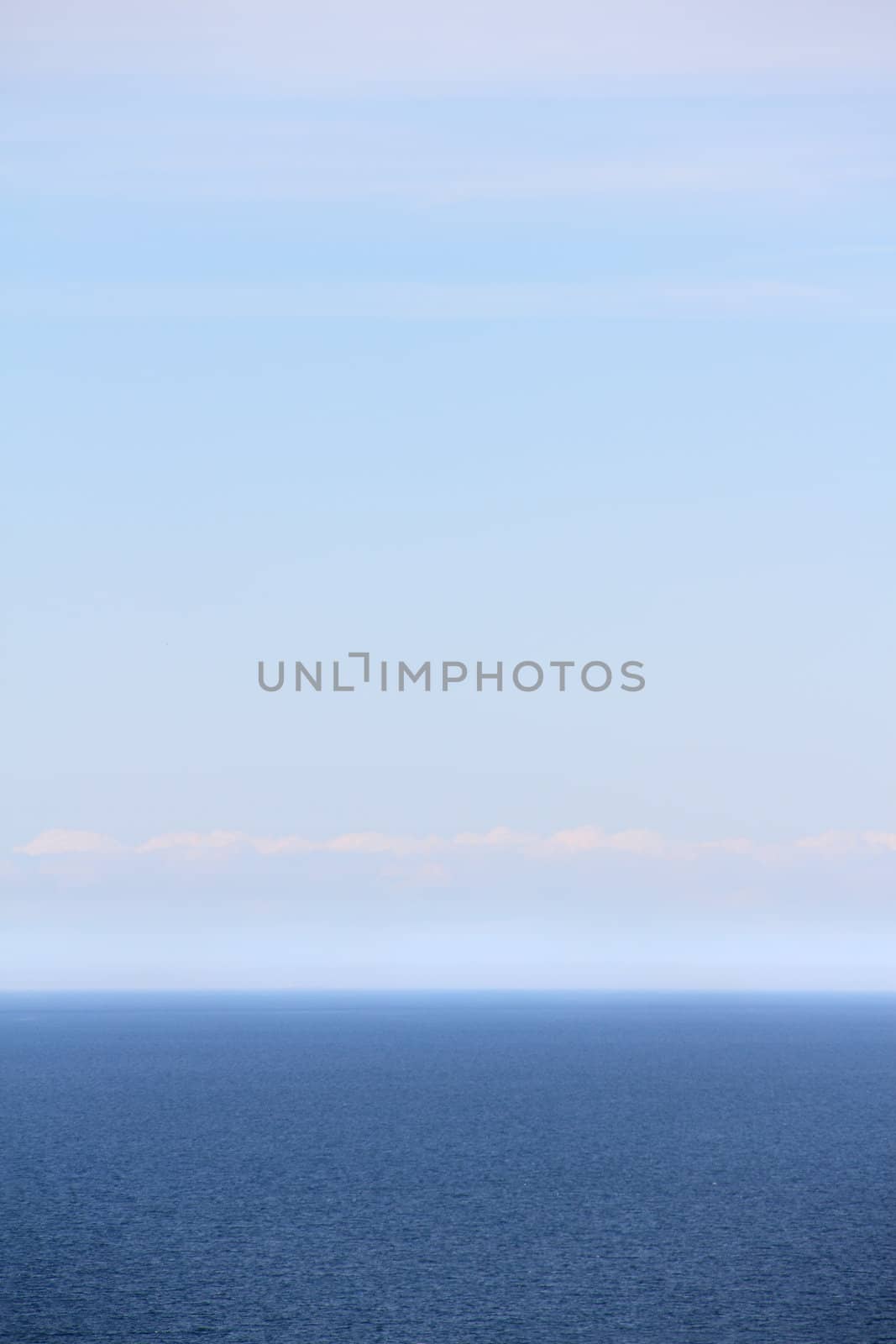 Vertical background of blue sea under clear sky