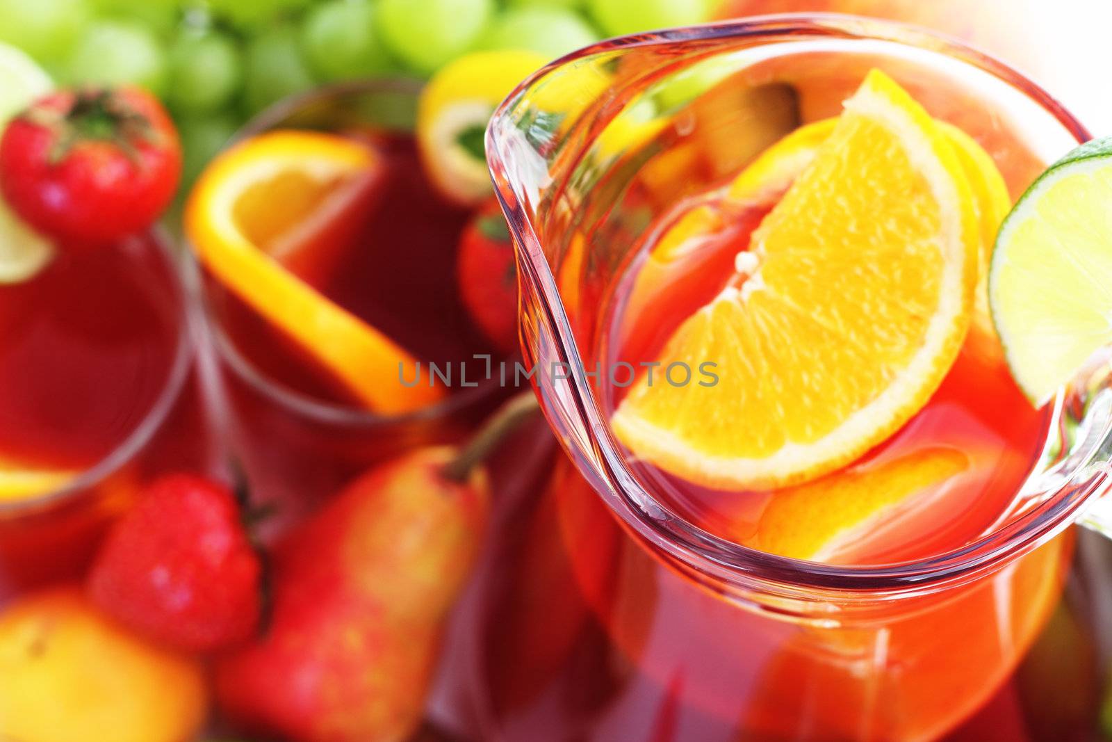 Refreshment beverage in pitcher with fruits  close-up background