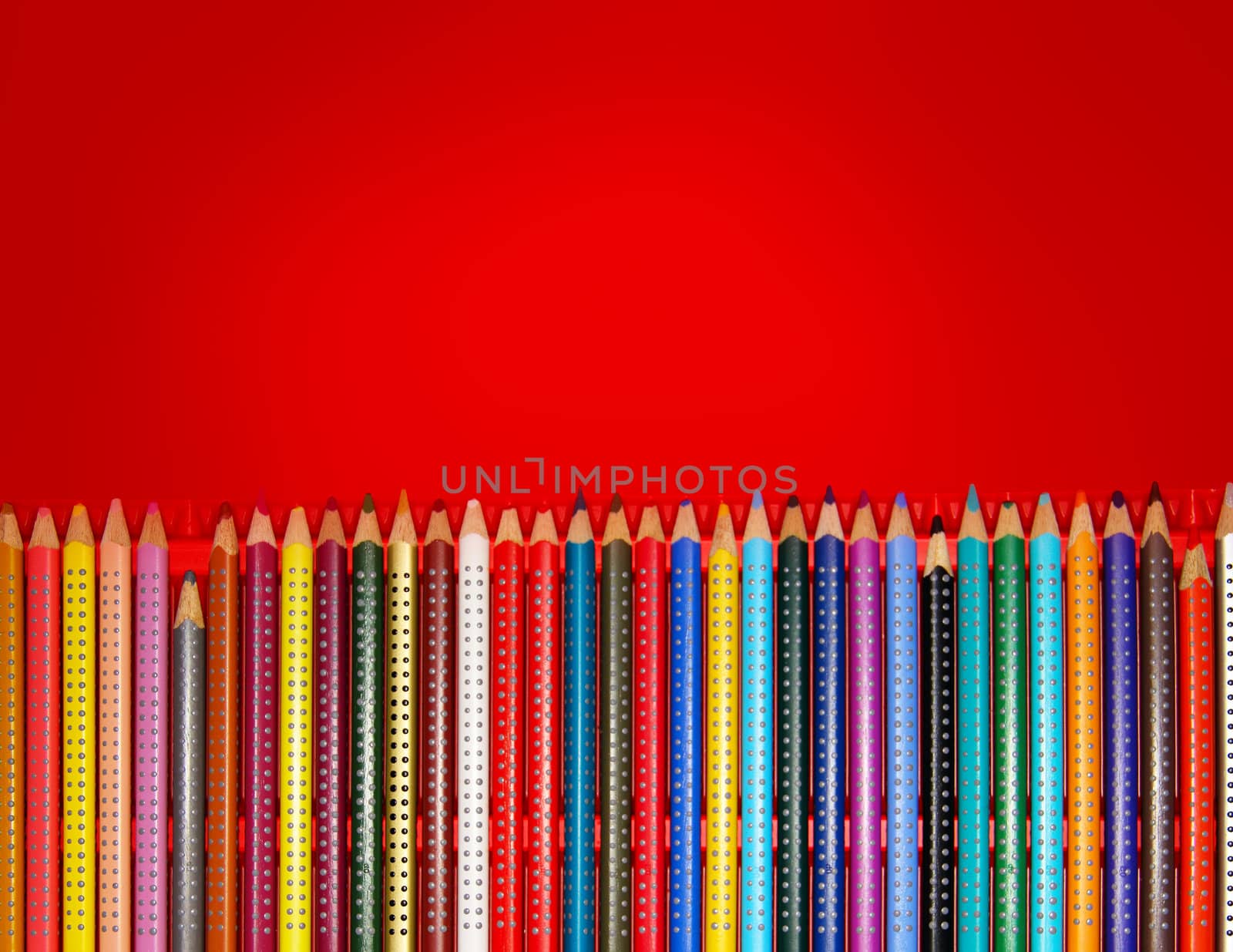 Colorful pencils in red box with copy space