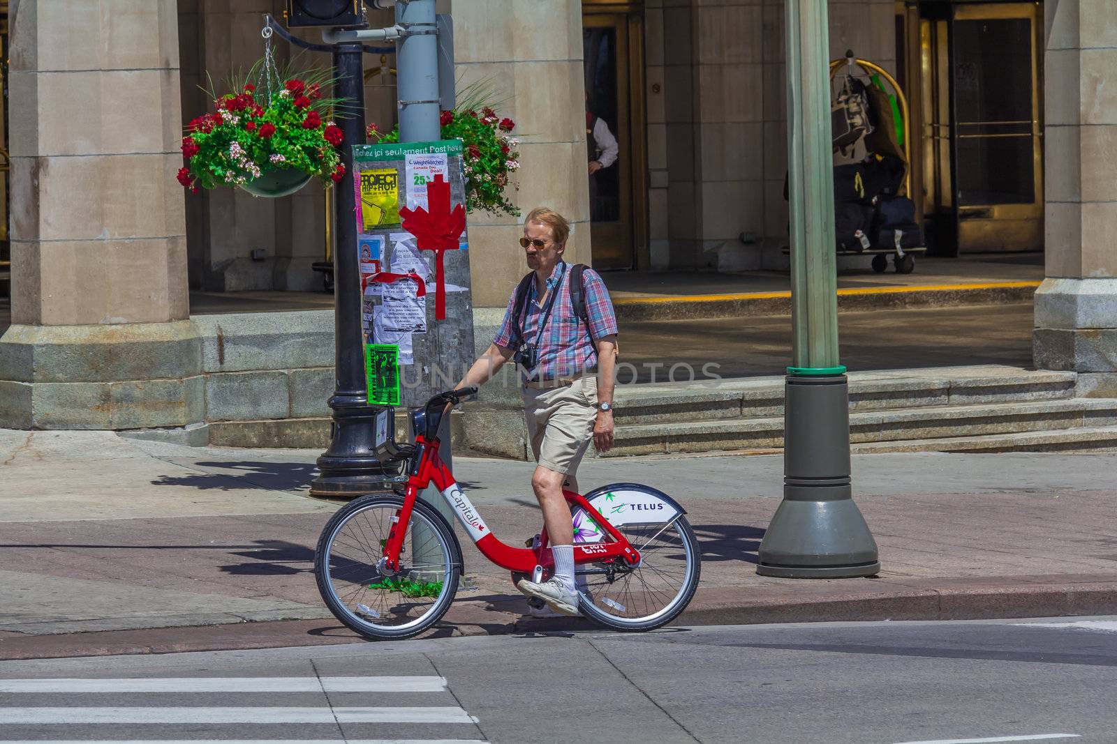 A bicyclist in Ottawa standing, waiting for someting, Ontario, Canada