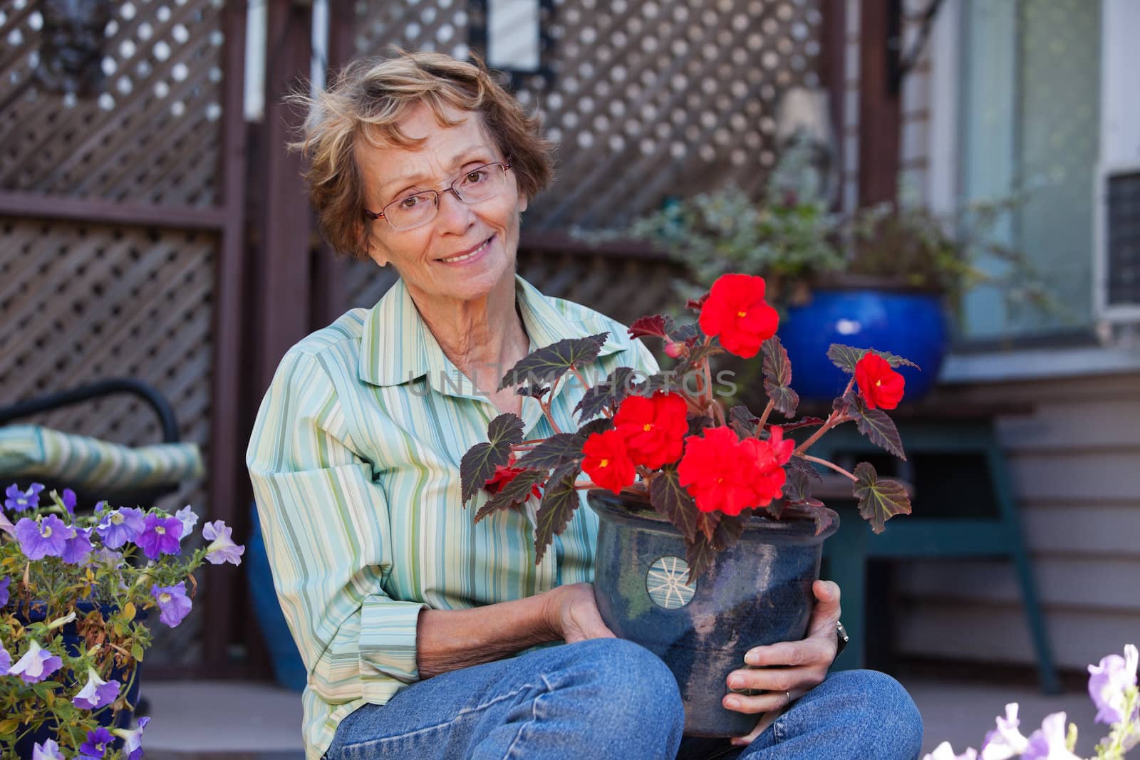 Portrait of beautiful senior woman holding potted plant