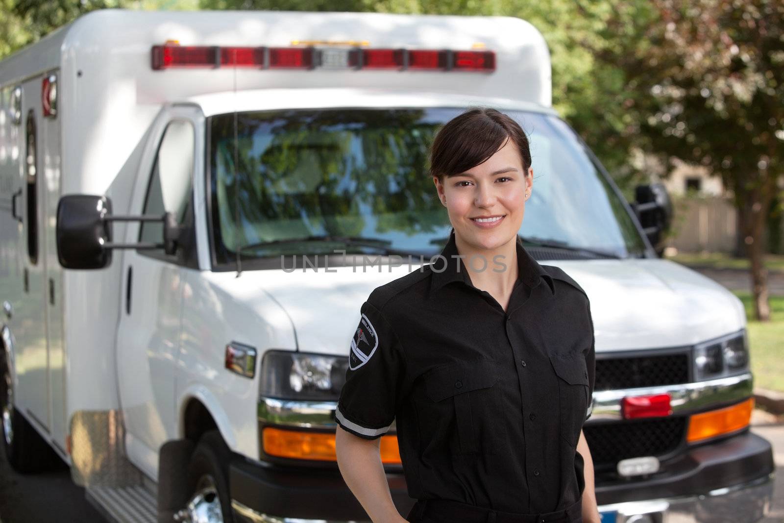 Portrait of attractive paramedic standing in front of ambulance