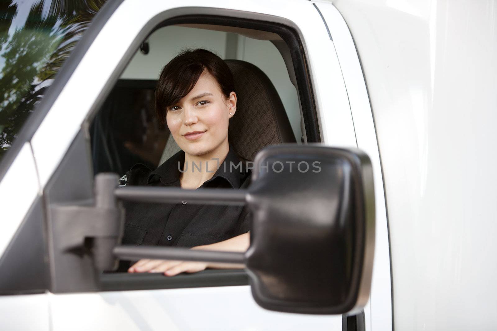 Portrait of a female paramedic in the drivers seat of an ambulance