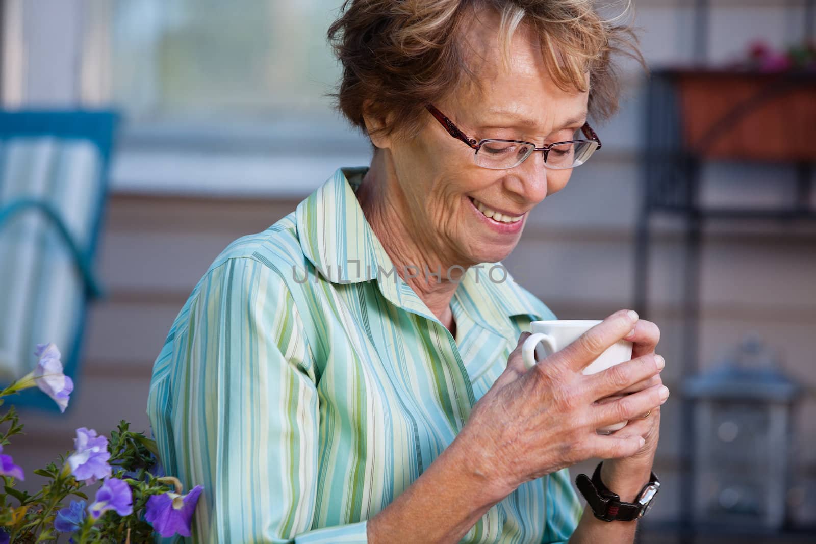 Senior woman enjoying a warm drink in back yard