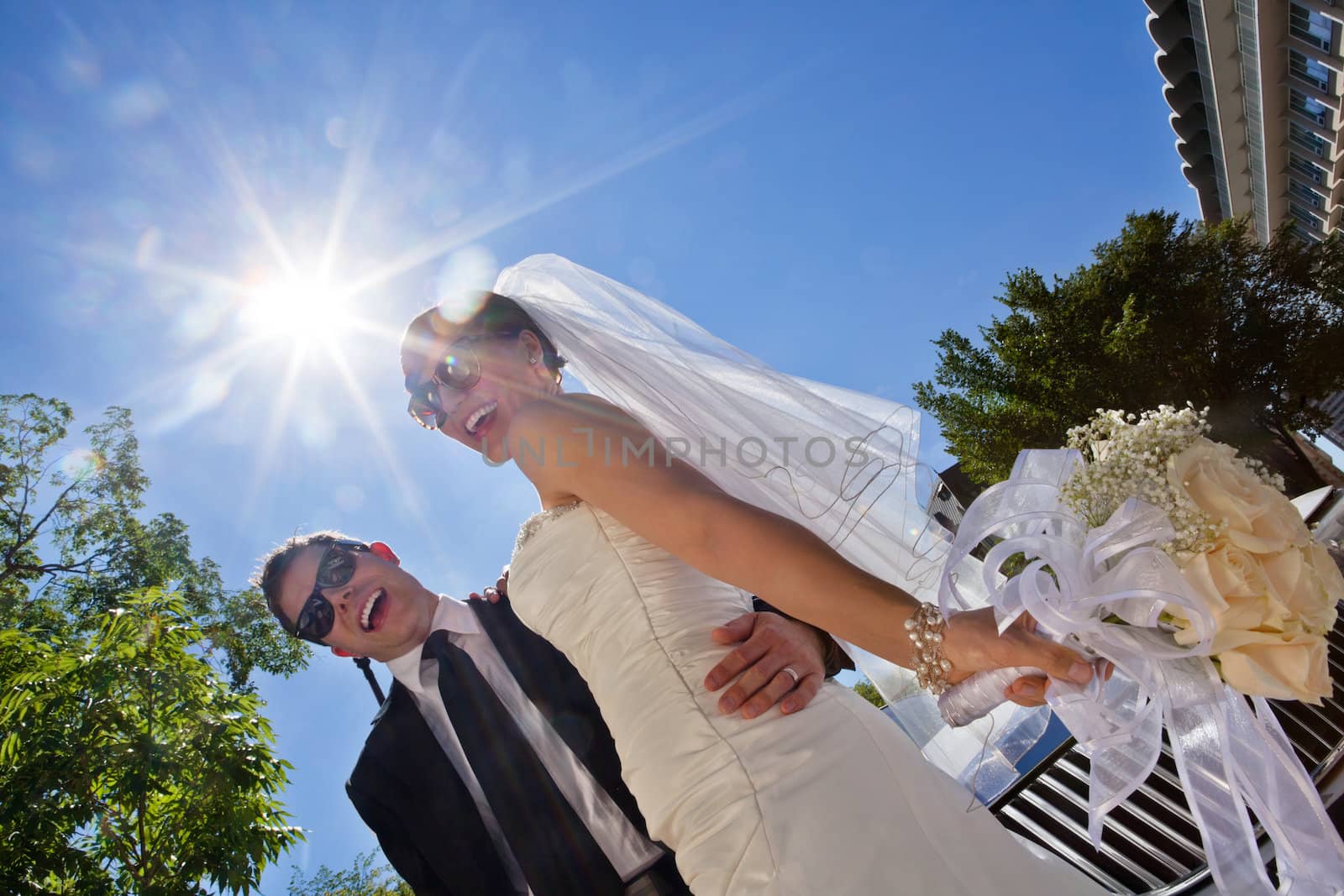 Happily married couple in sunglasses by leaf