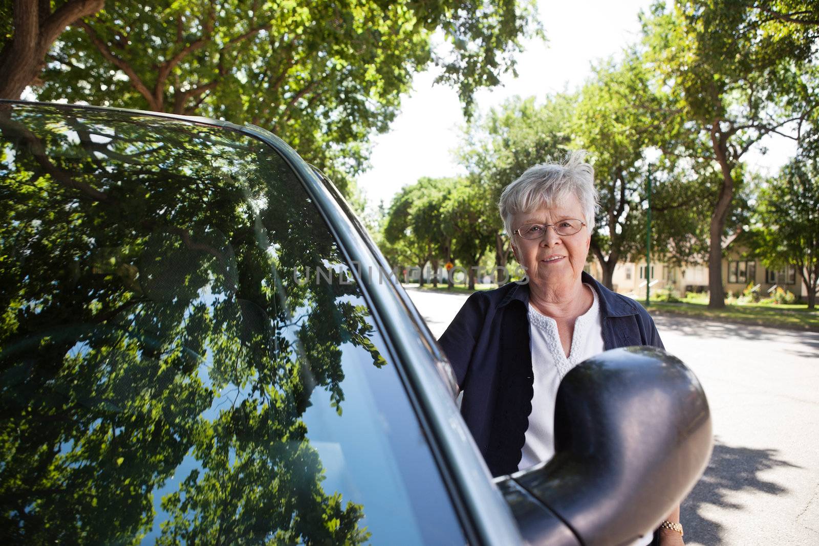 Portrait of a senior woman standing near car