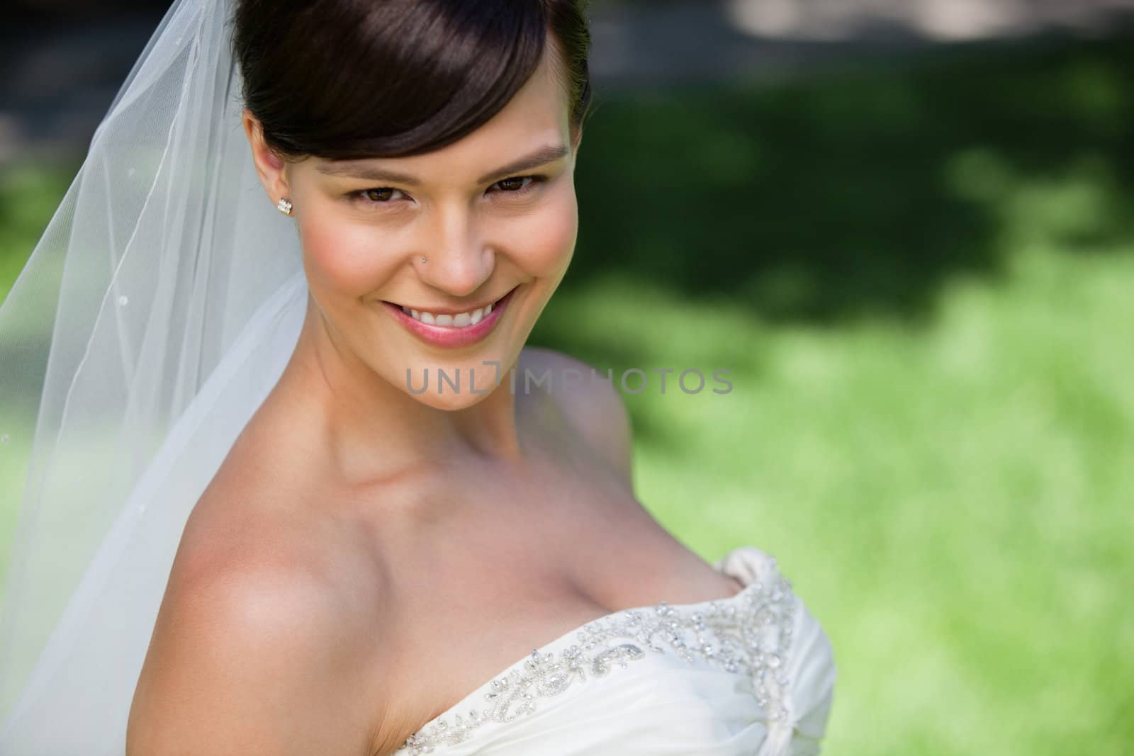 Attractive young bride smiling by leaf