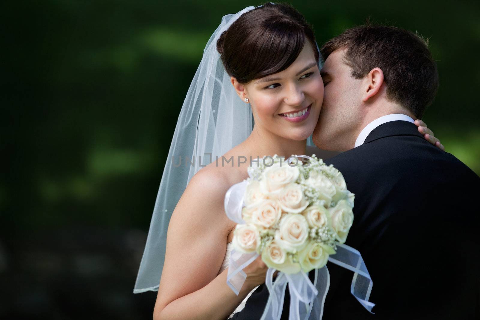 Young groom kissing on cheek  beautiful bride