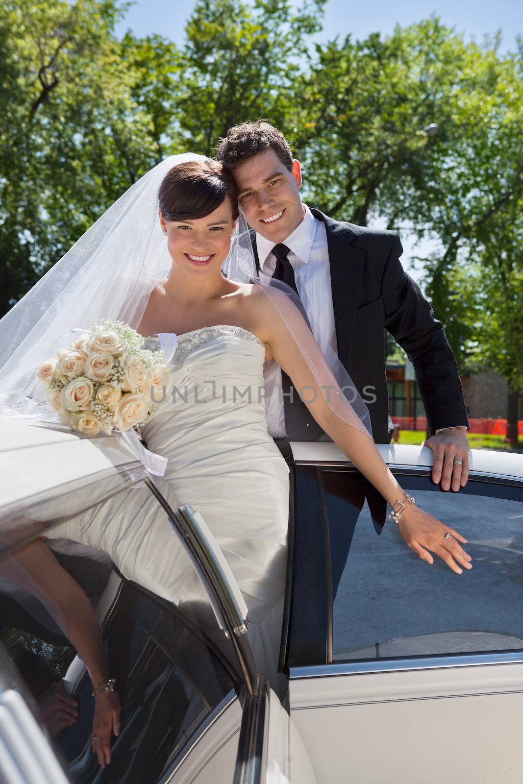 Happy newly wed couple getting in the car
