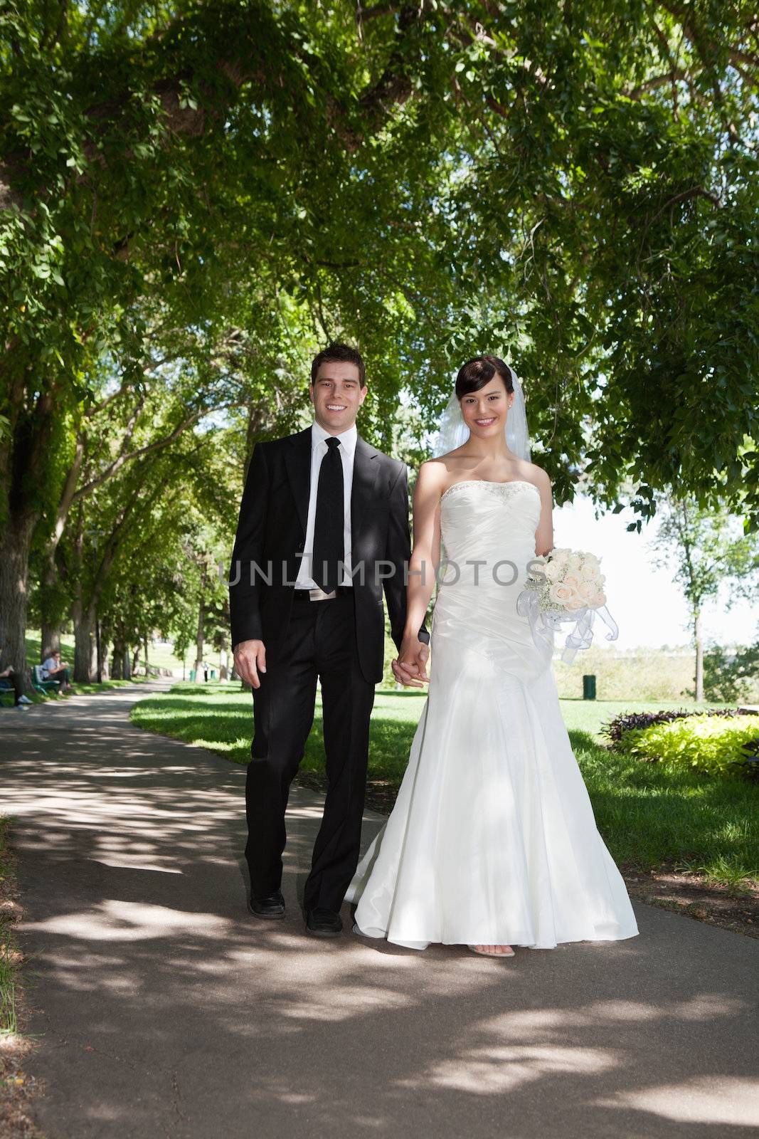 Portrait of newlywed young couple holding hands