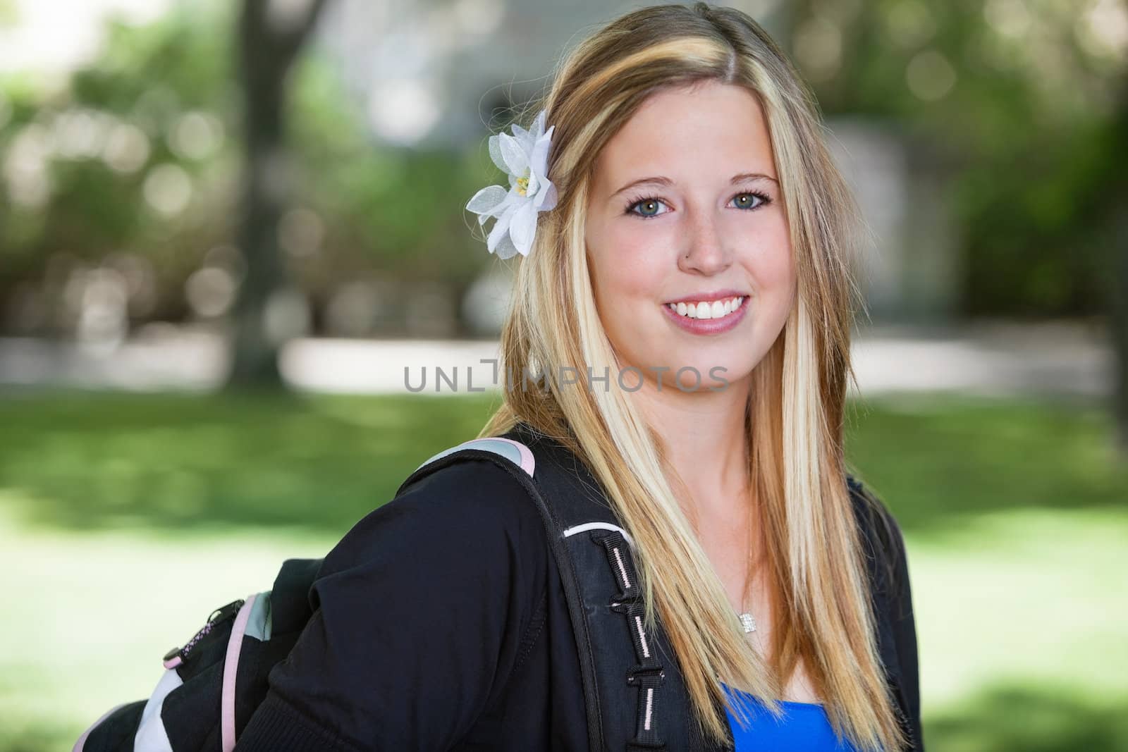 Close-up portrait of a cute teenage girl holding backpack