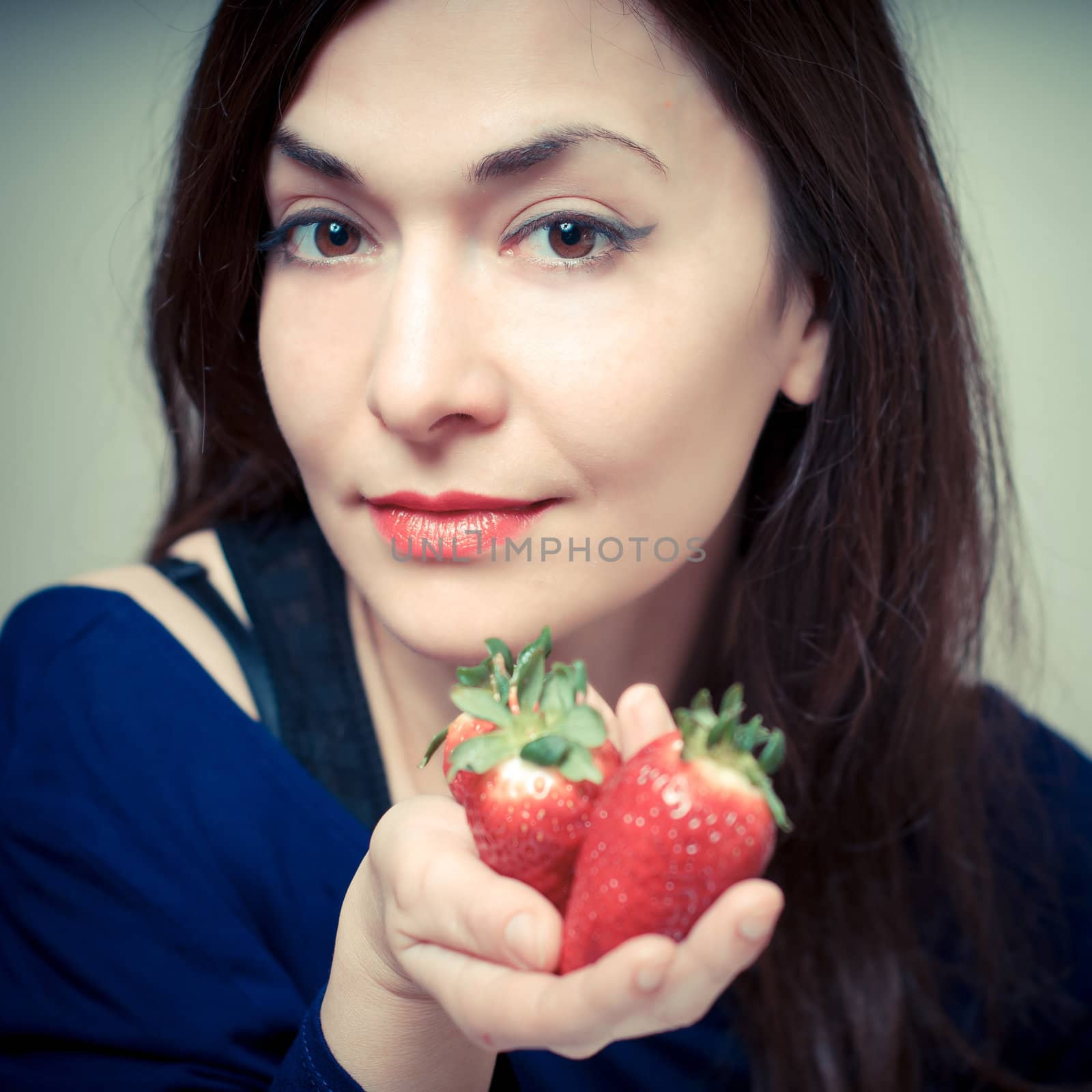 beautiful woman with strawberries on gray background