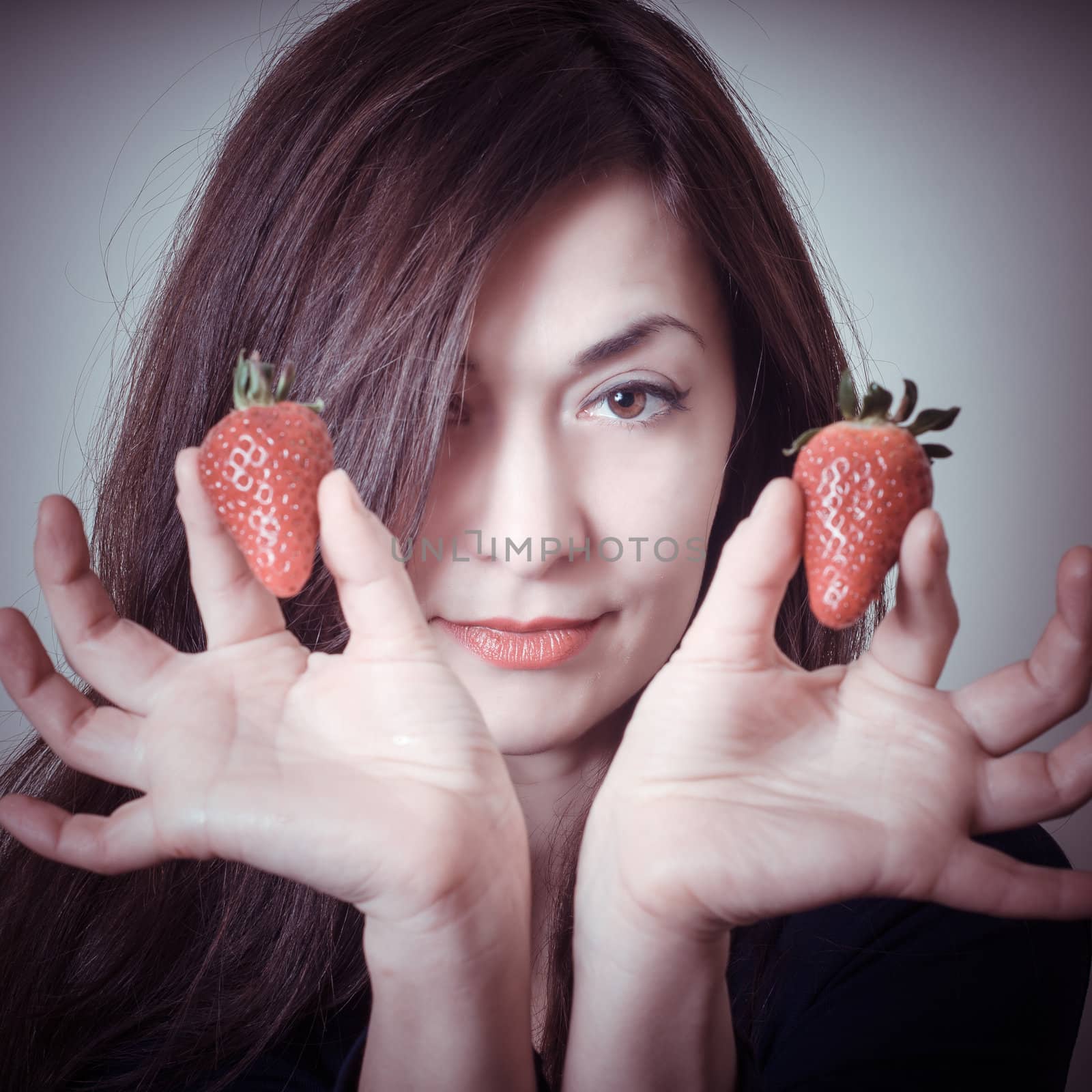 beautiful woman with strawberries on gray background