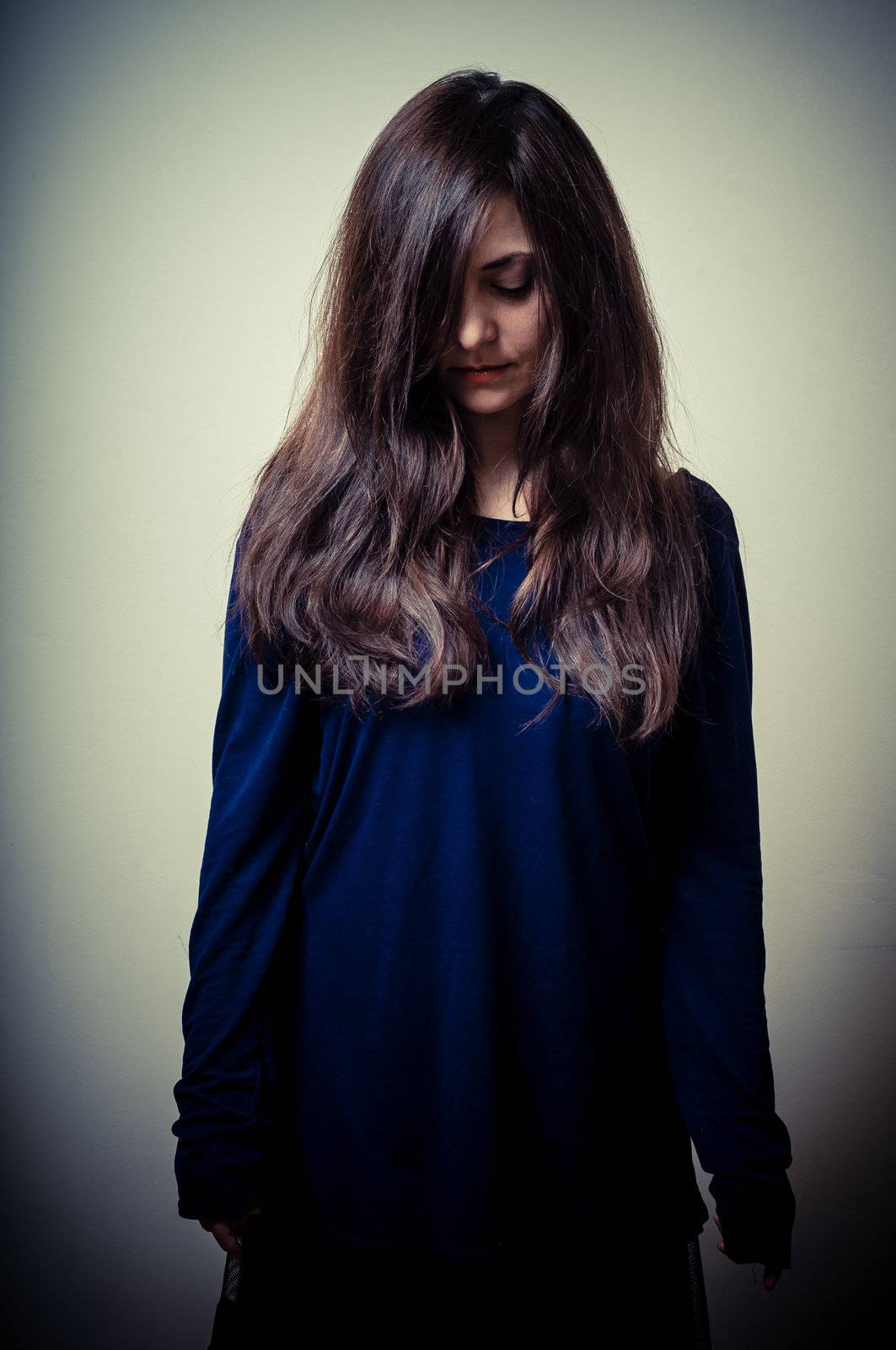 serious woman with long hair on vignetting background