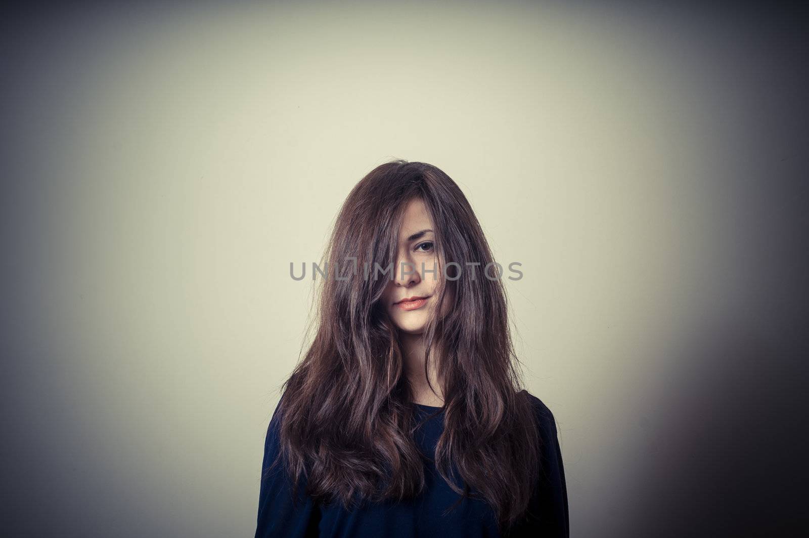 serious woman with long hair on vignetting background