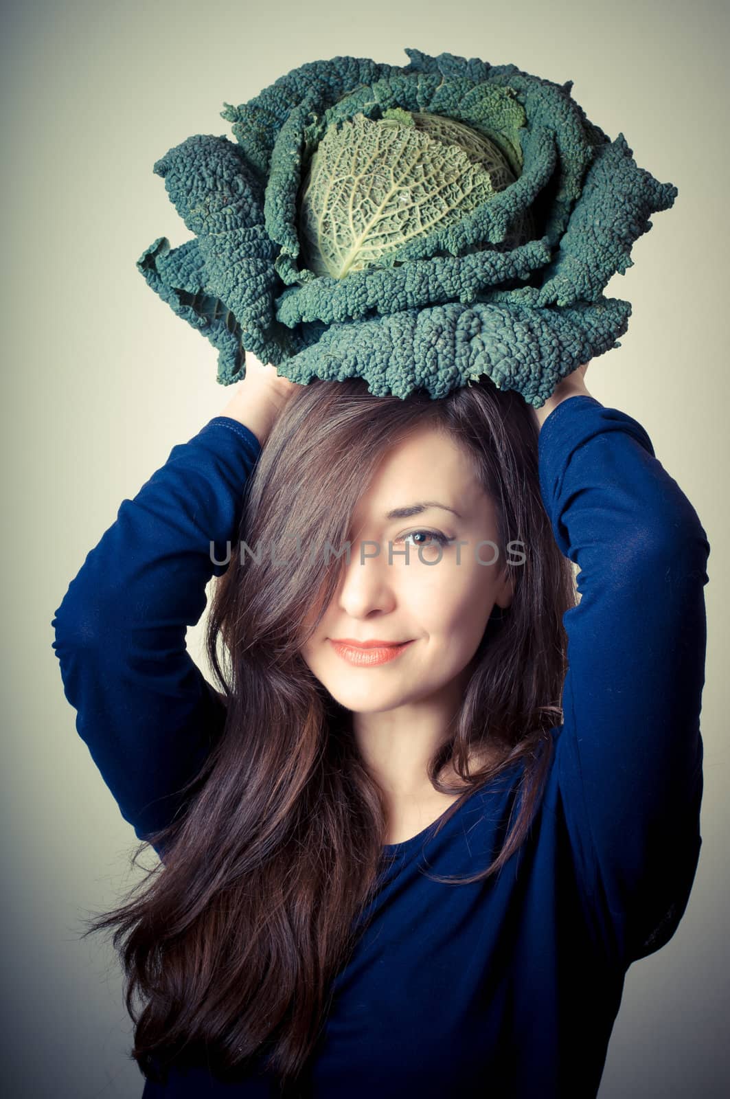 beautiful woman with savoy cabbage on gray background