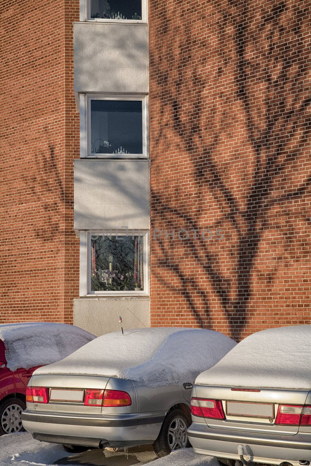 Parked automobiles outside an apartment house. Low afternoon light at wintertime - Denmark.