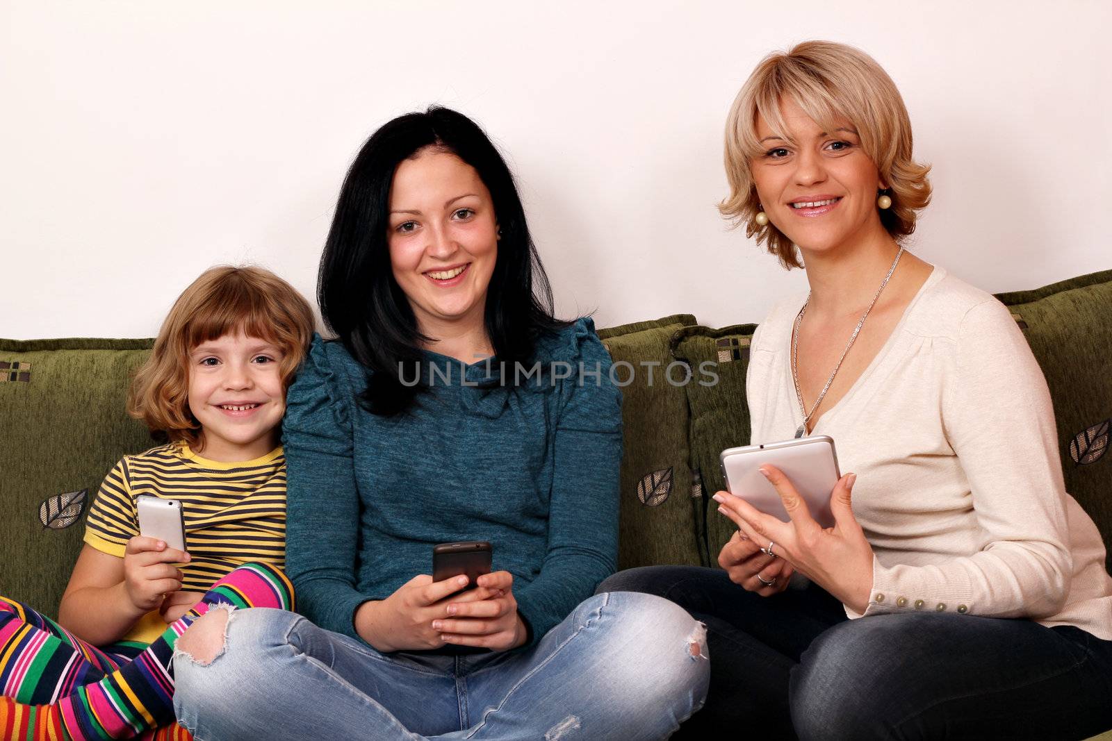 little girl teenage girl and woman play with smart phones and ta by goce