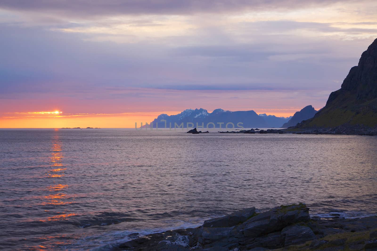 Scenic midnight sun over the ocean on Lofoten islands in Norway during polar day
