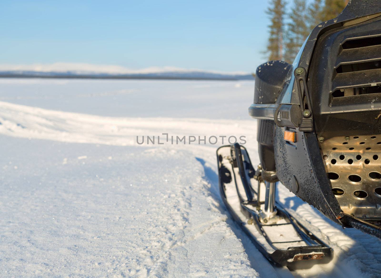 fragment of a snowmobile against a winter landscape