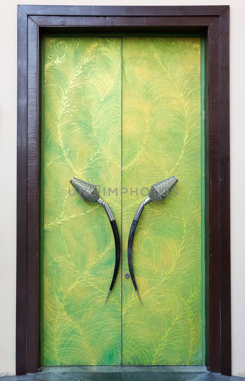 Plush green door with his hands in a brown frame
