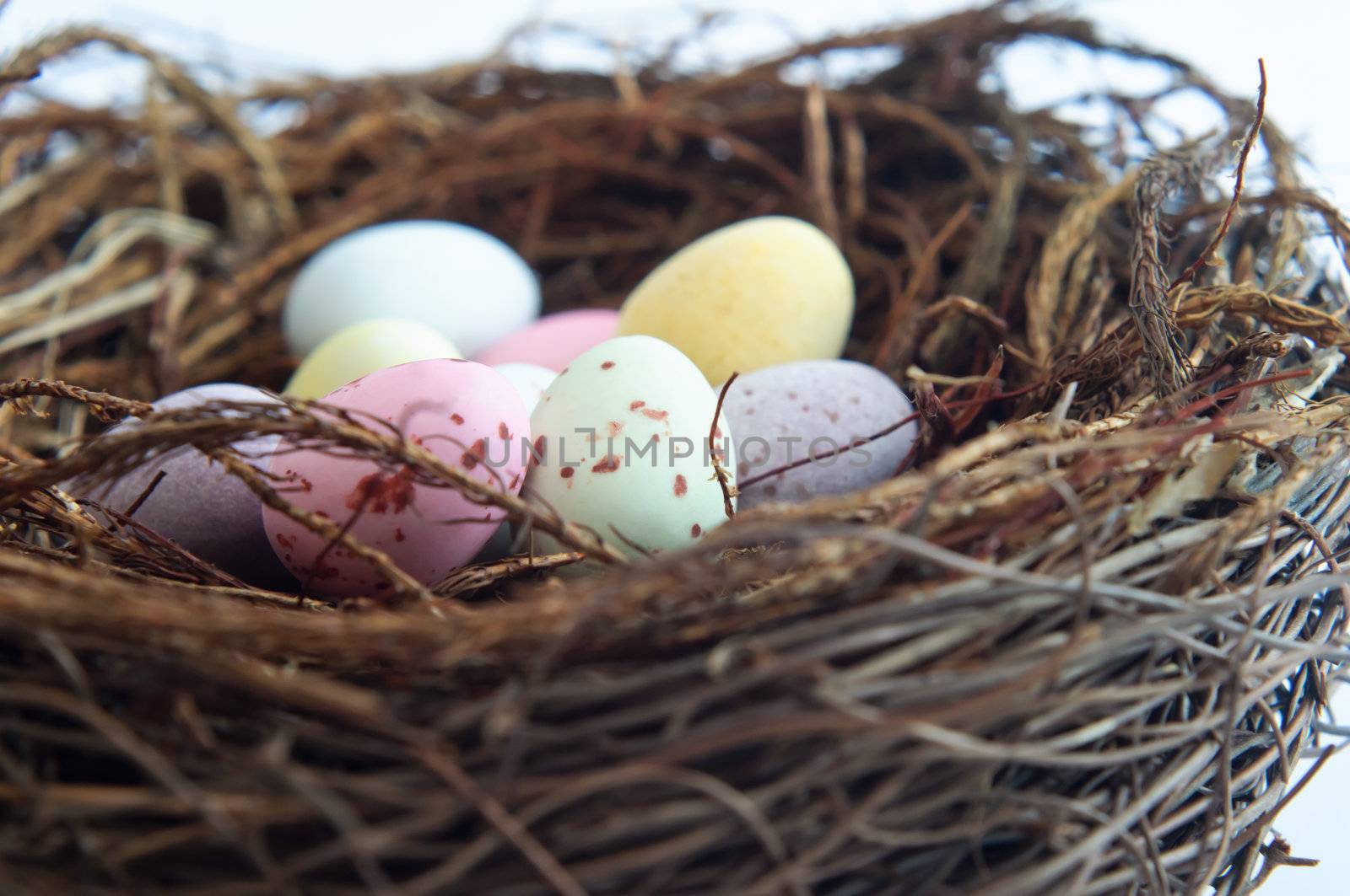 Close up of colourful Easter egg sweets in a bird's nest.  Cropped in-camera.