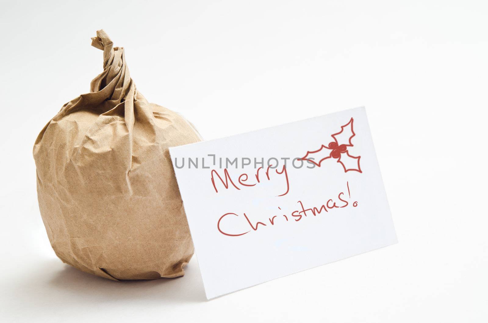 Conceptual image to convey a frugal Christmas.  An apple wrapped in brown paper with a gift card.