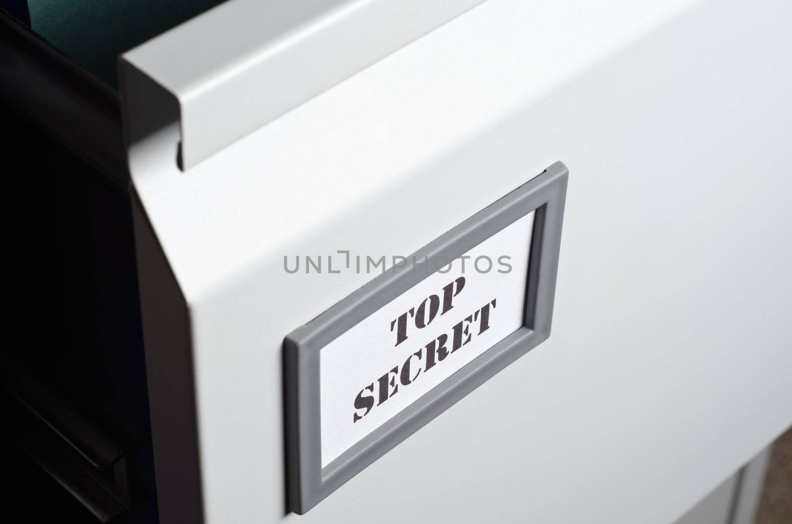 Close up of a partly opened filing cabinet drawer with a label marked 'Top Secret' at the front.  Landscape orientation.