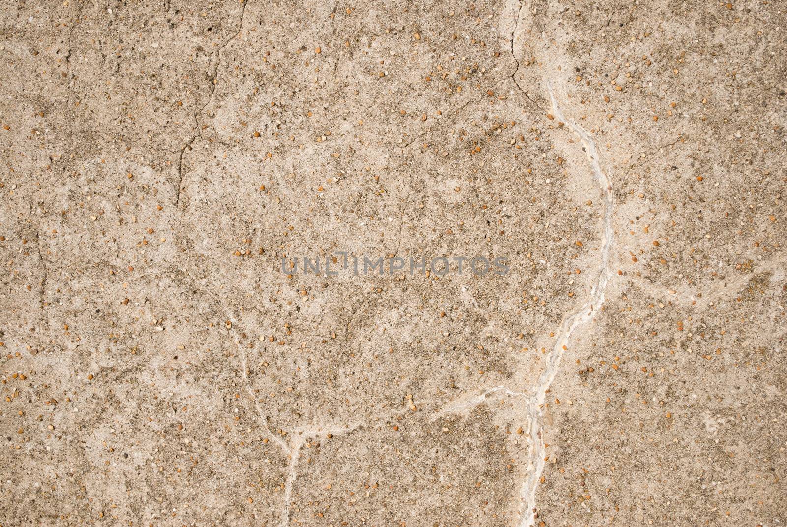 Background texture.  Light beige coloured old stone wall with cracks and small pieces of grit on surface.