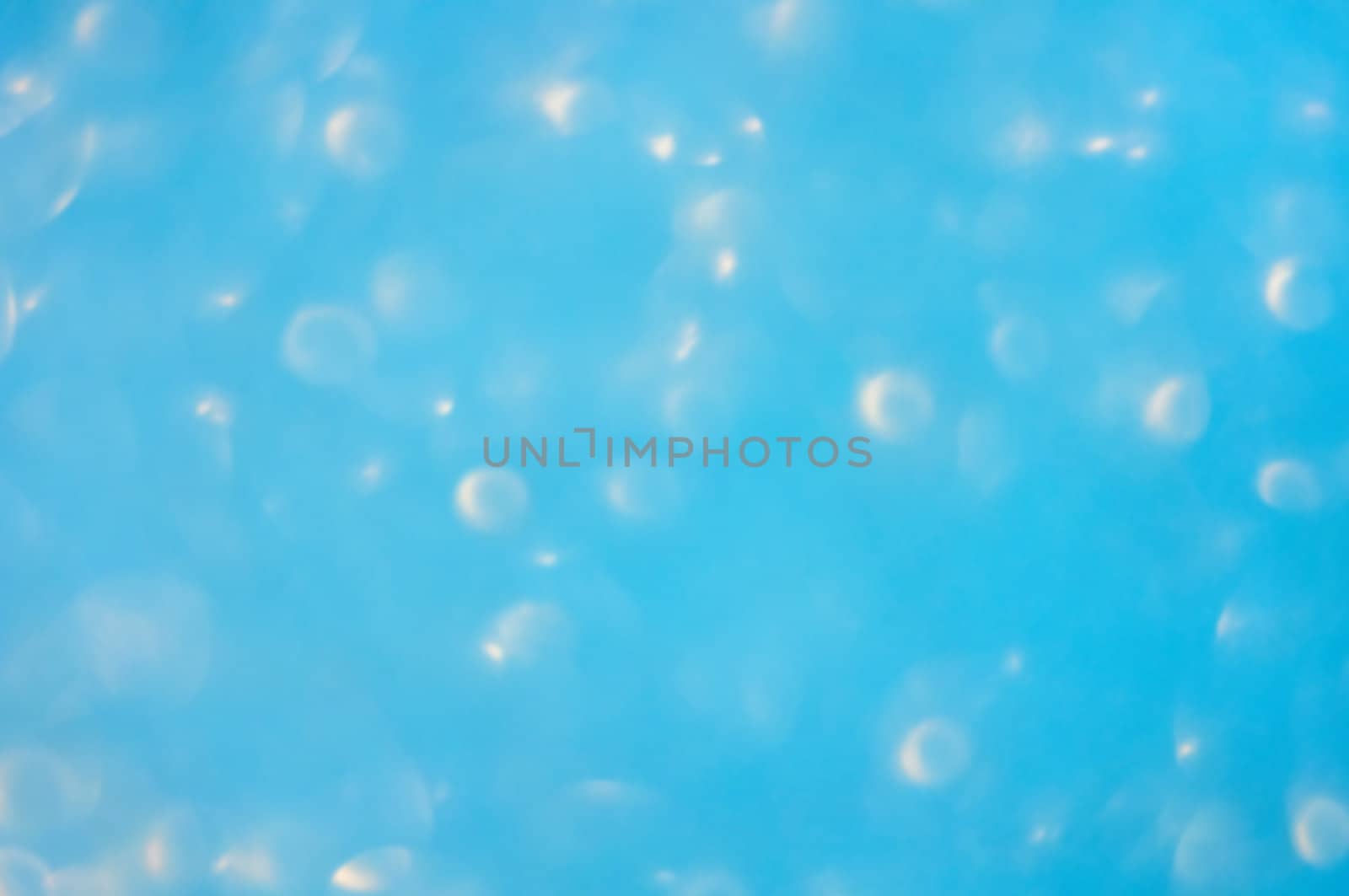 A soft photographed bokeh background in light blue with white lights creating an underwater bubble effect.
