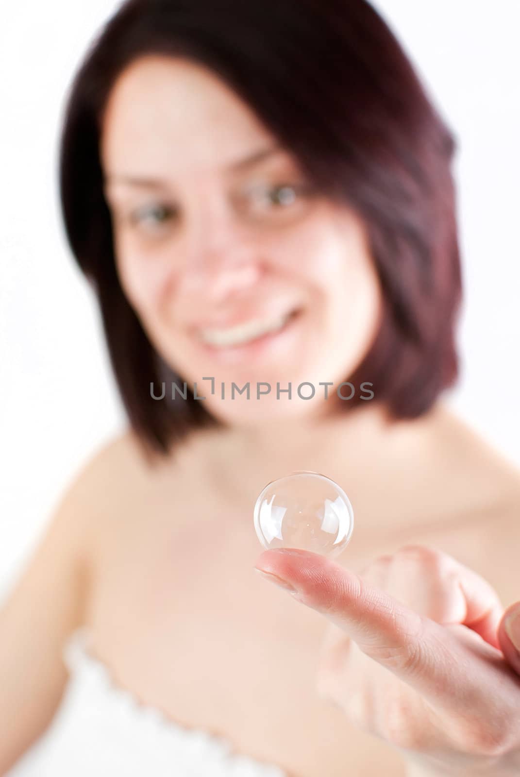 young attractive woman holding soap bubble on her finger