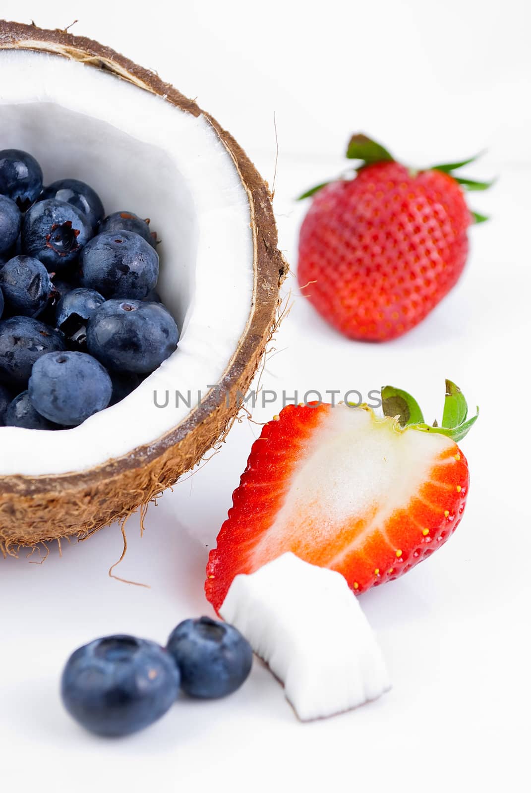 healthy fresh fruits - strawberry, blueberry and coconut isolated on white background