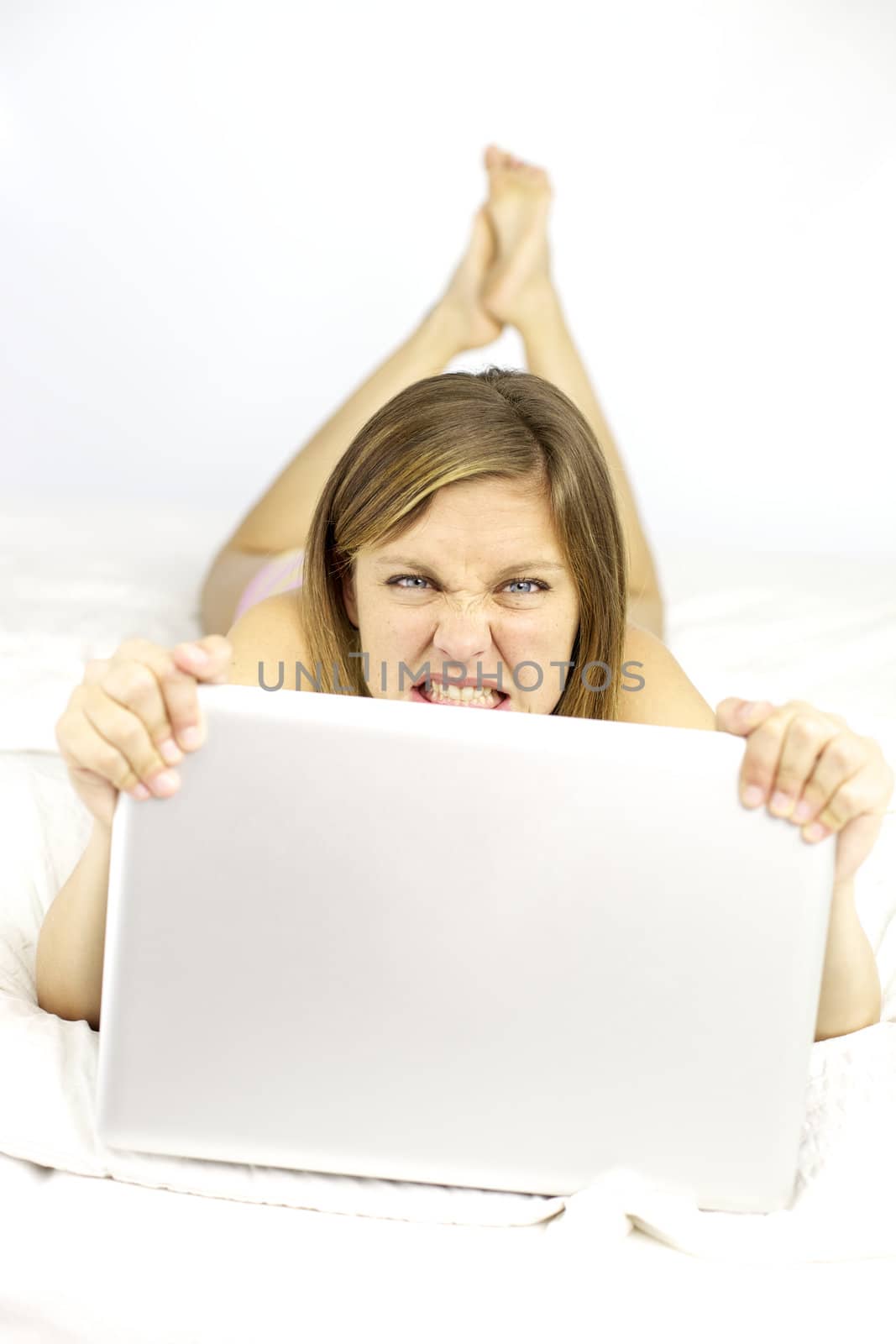 Blonde girl holding pc in bed very angru